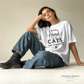 Woman wearing a white t-shirt with text sitting on the floor.