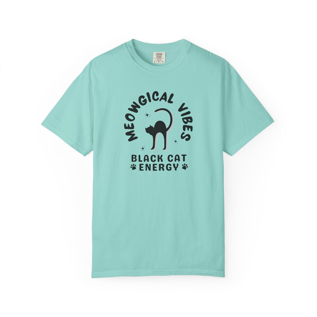 A light aqua blue short-sleeve t-shirt with a black graphic print on the front. The graphic features a black cat silhouette inside the text 'MEOWGICAL VIBES' arched above, and 'BLACK CAT ENERGY' with paw prints below.