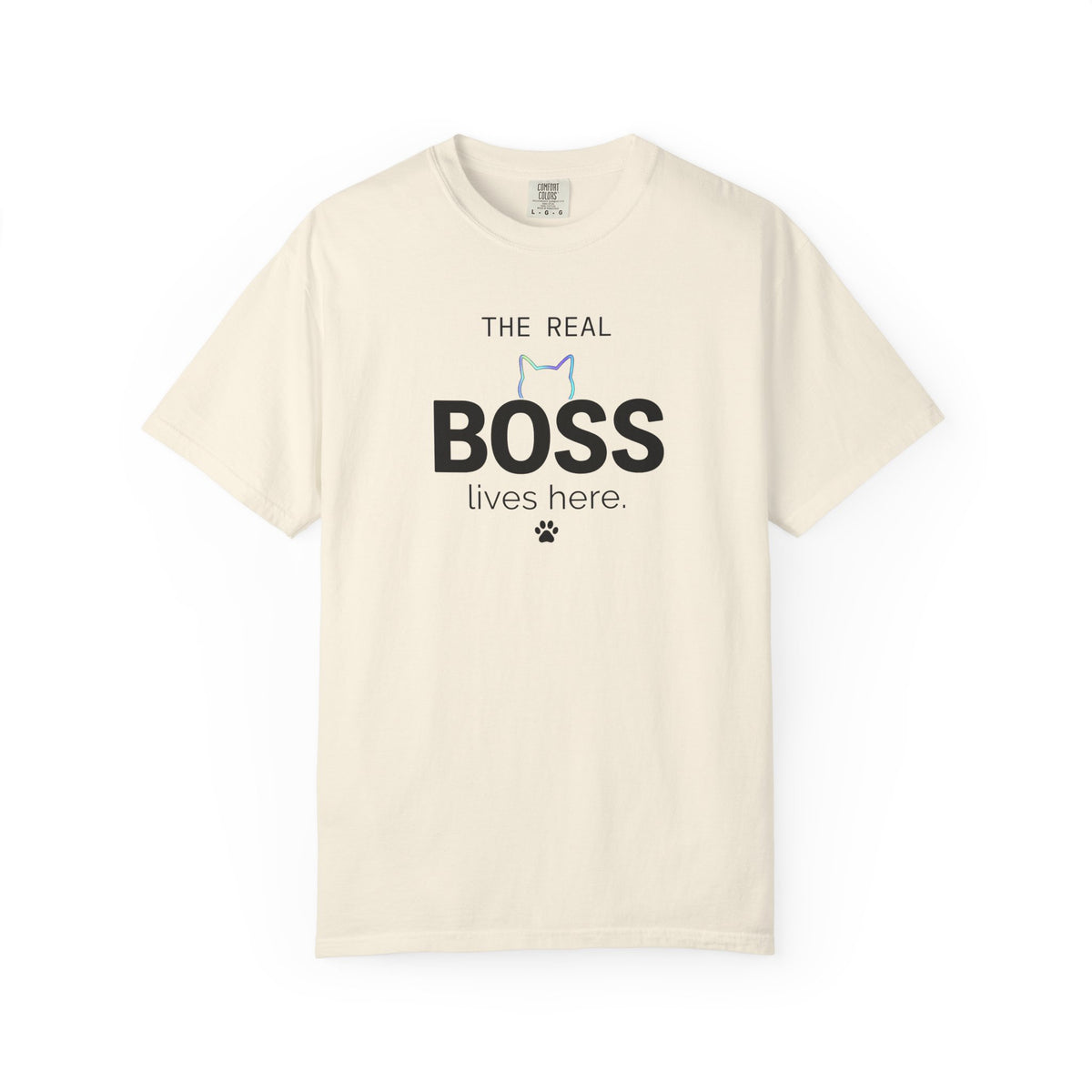 A cream-colored short-sleeve t-shirt with a graphic on the front that reads 'THE REAL BOSS lives here.' in black text, featuring a small blue and black cat outline and paw print.
