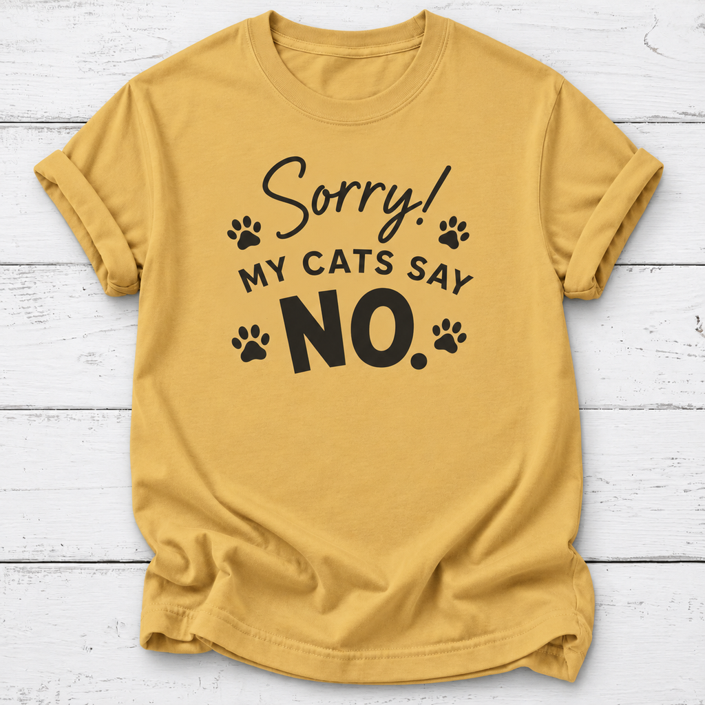 A mustard yellow short-sleeve t-shirt with a black graphic print that reads 'Sorry! MY CATS SAY NO.' accompanied by paw prints, laid flat on a white wood plank background.