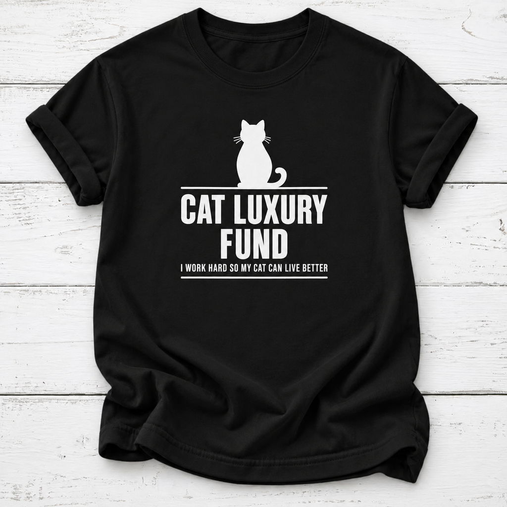Black T-shirt with a white cat silhouette and “Cat Luxury Fund — I Work Hard So My Cat Can Live Better” lettering, laid flat on white wooden boards.