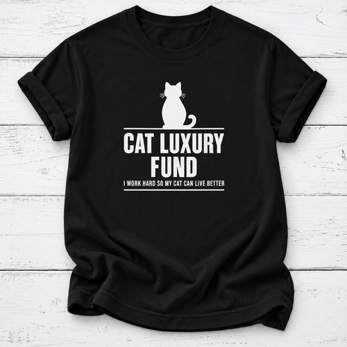 Black T-shirt with a white cat silhouette and “Cat Luxury Fund — I Work Hard So My Cat Can Live Better” lettering, laid flat on white wooden boards.