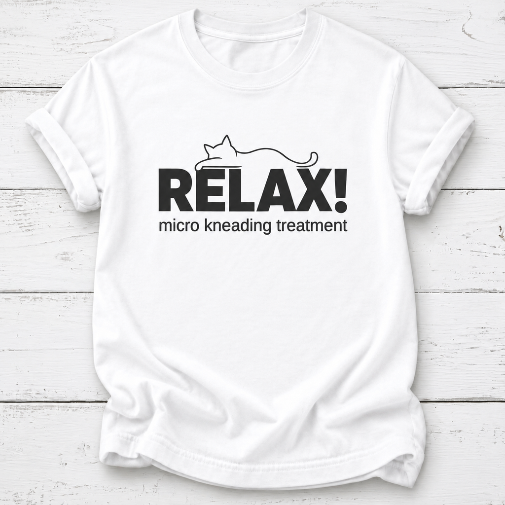A white short-sleeve crewneck t-shirt with a black graphic print on the front. The graphic features the word 'RELAX!' in bold capital letters with a minimalist line drawing of a cat above it, and the phrase 'micro kneading treatment' printed below in a smaller font.